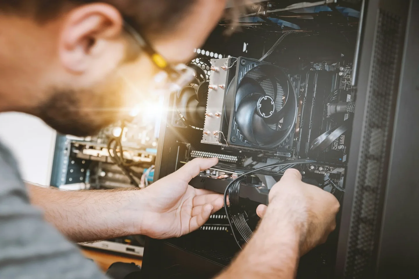 Mãos de um técnico trabalhando nos componentes internos de um computador